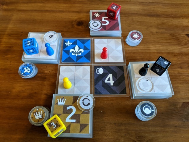 A piecepack on a wooden table. There are several square tiles, dice, coins, and plastic pawns, each in four colors.