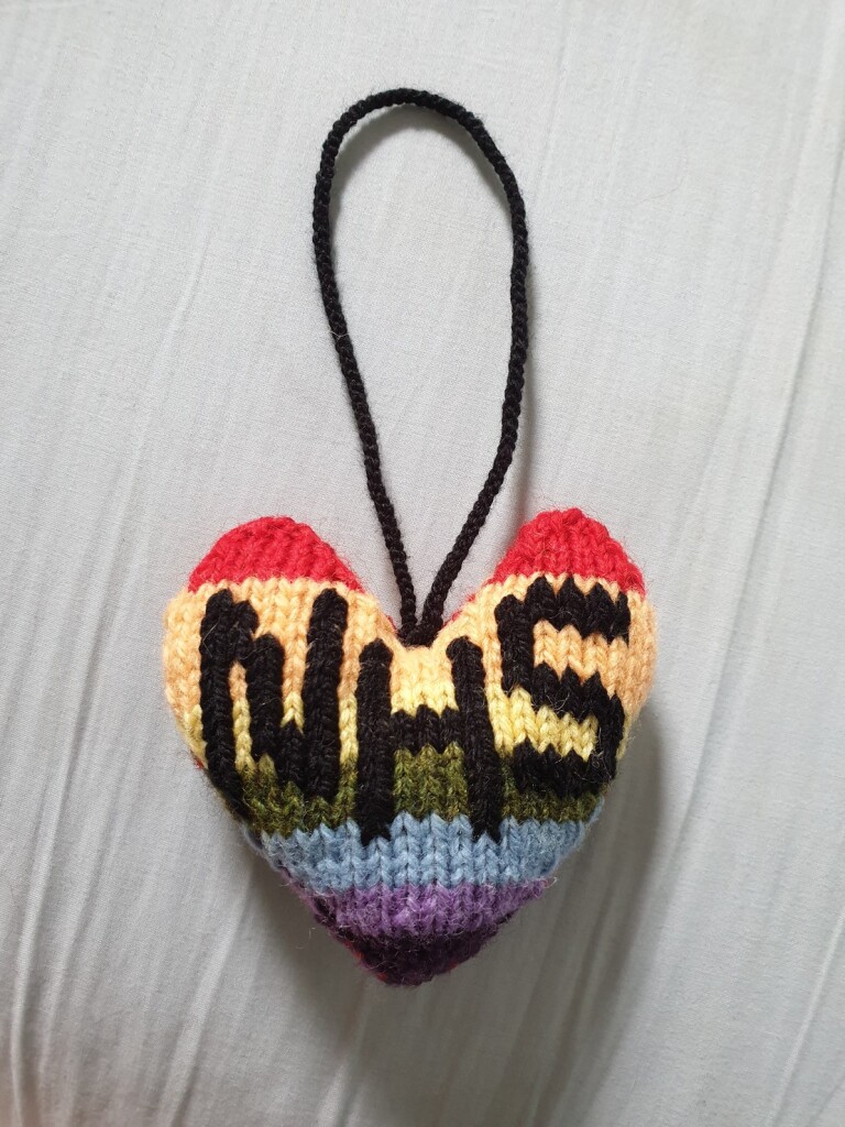 knitted rainbow heart with NHS embroidered on it