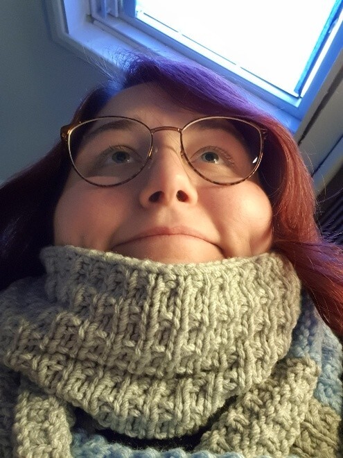 selfie from below, chubby cheeks, blanket scarf, inane expression