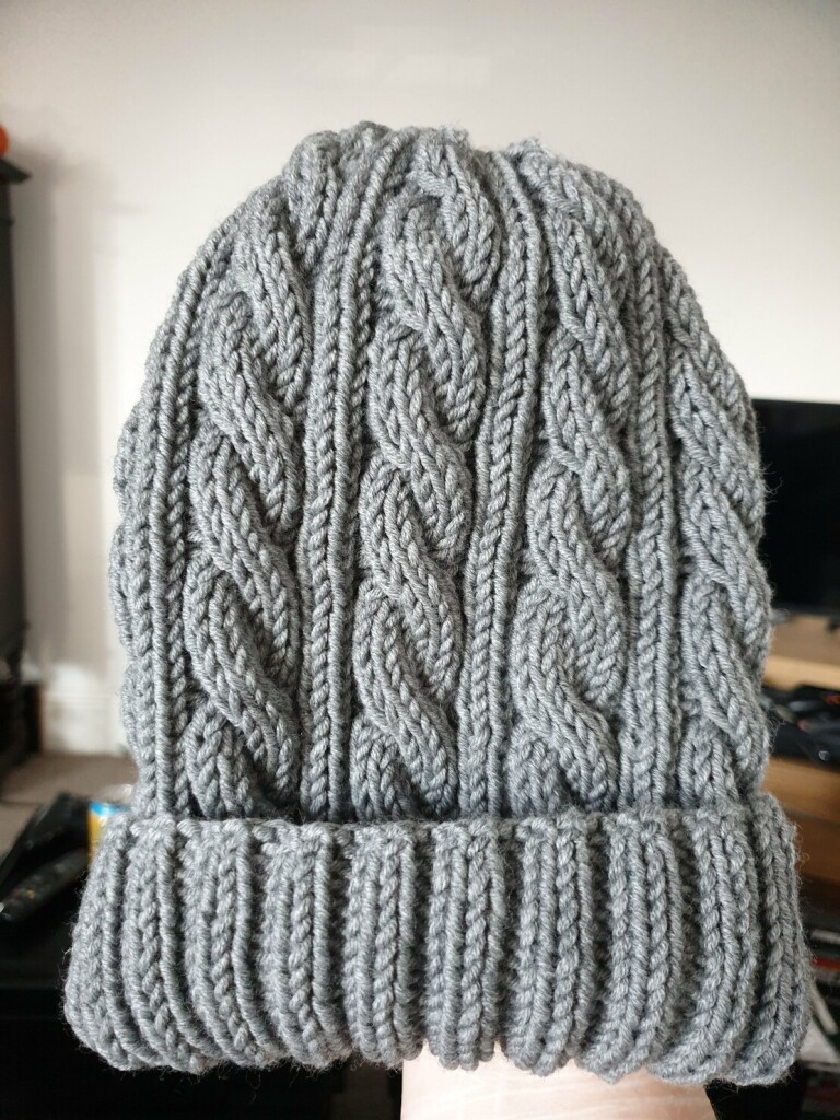 a grey hat with cabled lines. it is very soft and squishy and warm